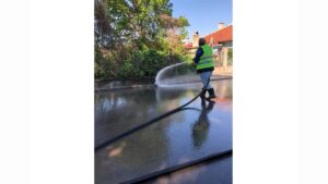 Служител мие улица с вода