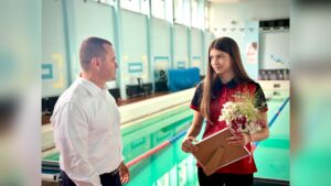 Кметът на Русе награждава младата плувкиня Ан-Мари Младенова.
